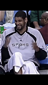 A Man Wearing A Spurs Jersey Sits In A Stadium GIF