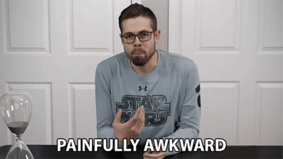 A Man Wearing A Star Wars Shirt Says Painfully Awkward In Front Of An Hourglass GIF