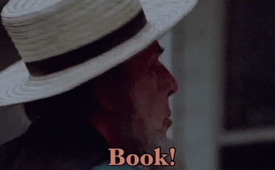 A Man Wearing A Straw Hat Says " Book " On The Screen GIF