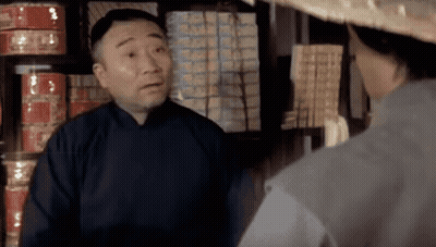 A Man Wearing A Straw Hat Talks To Another Man GIF