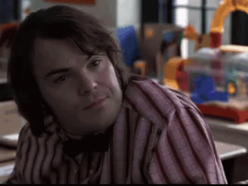 A Man Wearing A Striped Shirt And A Bow Tie Is Sitting At A Table . GIF