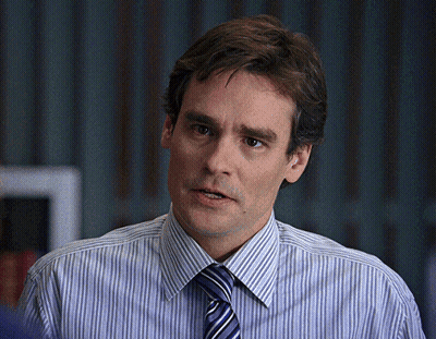 A Man Wearing A Striped Shirt And Tie Looks To The Side GIF
