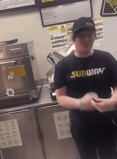 A Man Wearing A Subway Shirt Is Standing In Front Of An Oven GIF