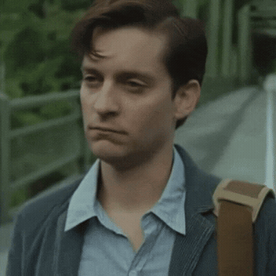 A Man Wearing A Suit And A Blue Shirt Is Walking Down A Sidewalk With A Backpack . GIF