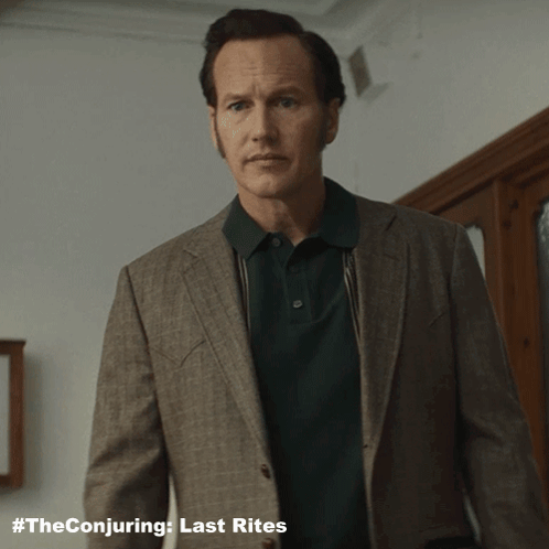 A Man Wearing A Suit And A Green Polo Shirt With The Conjuring Last Rites Written On The Bottom GIF