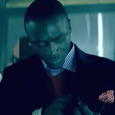A Man Wearing A Suit And Striped Shirt Is Looking Down GIF