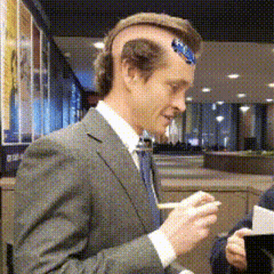 A Man Wearing A Suit And Tie Has A Sticker On His Head GIF