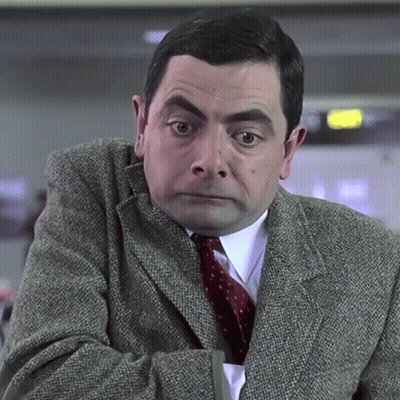 A Man Wearing A Suit And Tie Is Looking At The Camera GIF