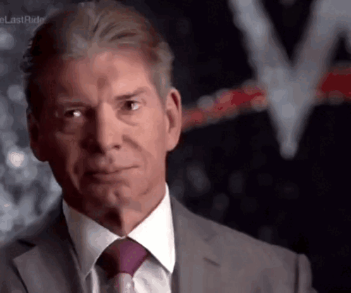A Man Wearing A Suit And Tie Is Looking At The Camera GIF