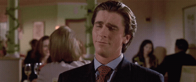 A Man Wearing A Suit And Tie Is Making A Funny Face GIF
