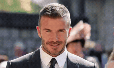 A Man Wearing A Suit And Tie Is Smiling For The Camera GIF