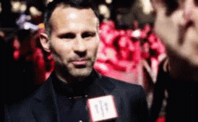 A Man Wearing A Suit And Tie Is Talking Into A Microphone With The Number 11 On It GIF