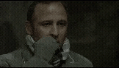 A Man Wearing A Suit And Tie Is Talking On A Telephone . GIF