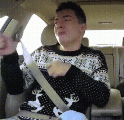 A Man Wearing A Sweater With A Deer On It Is Sitting In The Back Seat Of A Car GIF