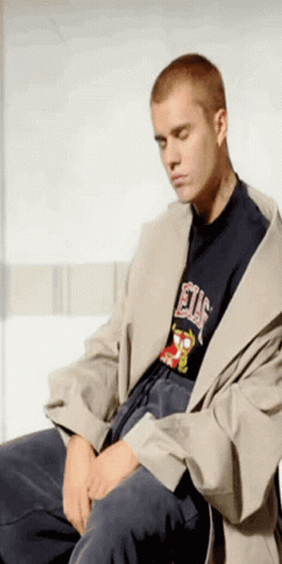 A Man Wearing A T-Shirt That Says Elf Is Sitting Down GIF