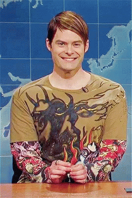 A Man Wearing A T-Shirt With A Bull On It Is Smiling GIF