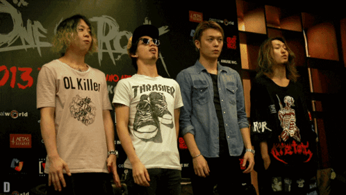 A Man Wearing A Thrasher Shirt Stands In Front Of A Sign That Says 2013 GIF