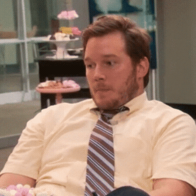 A Man Wearing A Tie And A Yellow Shirt Is Sitting In A Chair GIF