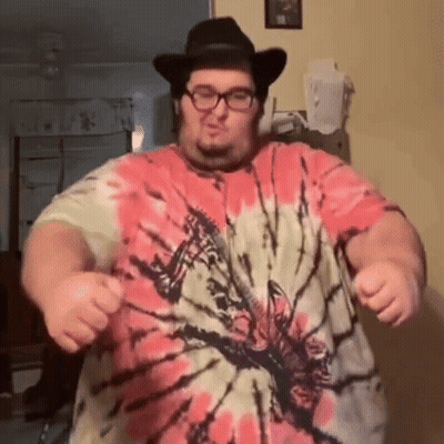 A Man Wearing A Tie Dye Shirt And A Cowboy Hat Is Dancing GIF