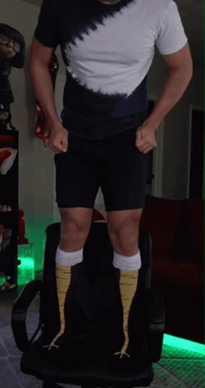 A Man Wearing A Tie Dye Shirt And Shorts Is Standing On A Chair GIF