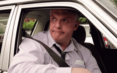 A Man Wearing A Tie Is Sitting In A Car And Looking Out The Window GIF