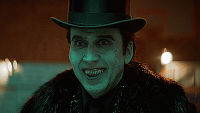 A Man Wearing A Top Hat And A Fur Coat Has Sharp Teeth GIF