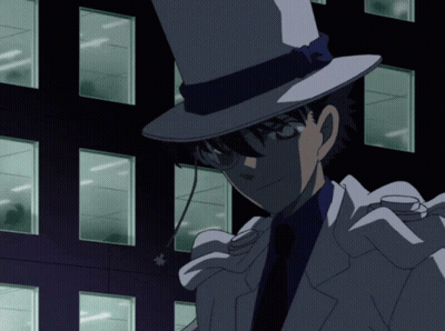 A Man Wearing A Top Hat And Glasses Stands In Front Of A Dark Building GIF