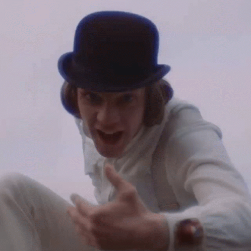 A Man Wearing A Top Hat And Suspenders Is Making A Funny Face GIF