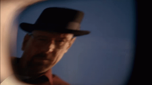 A Man Wearing A Top Hat Is Looking Through A Lens GIF