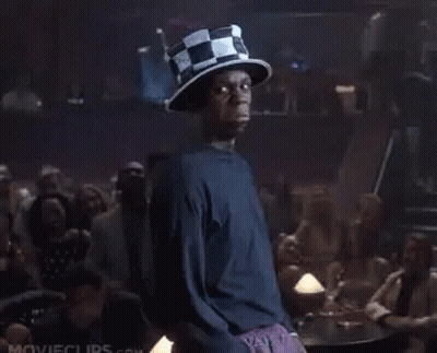 A Man Wearing A Top Hat Is Standing In Front Of A Crowd Of People In A Bar . GIF