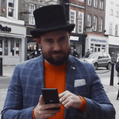 A Man Wearing A Top Hat Looking At His Phone GIF