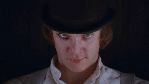 A Man Wearing A Top Hat With A Fake Eyelash On His Eye GIF