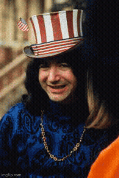 A Man Wearing A Top Hat With A Flag On It GIF