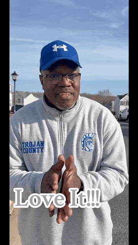A Man Wearing A Trojan County Sweatshirt And A Blue Hat GIF