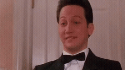 A Man Wearing A Tuxedo And Bow Tie Is Making A Funny Face . GIF