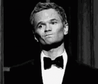 A Man Wearing A Tuxedo And Bow Tie Is Making A Funny Face . GIF