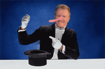 A Man Wearing A Tuxedo And White Gloves Is Pointing At A Top Hat GIF