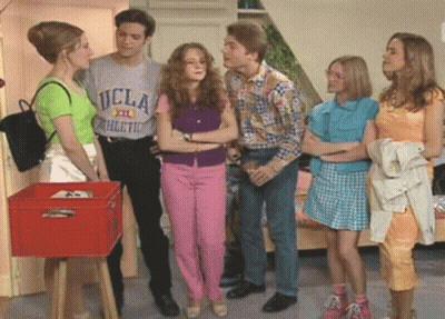 A Man Wearing A Ucla Athletic T-Shirt Talks To Three Women GIF