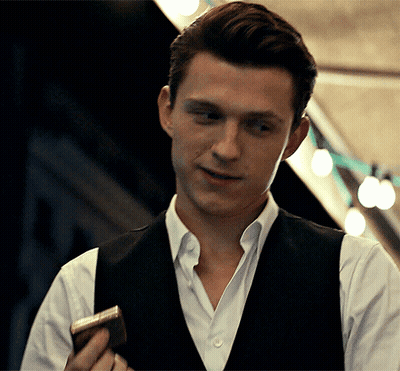 A Man Wearing A Vest And A White Shirt Is Holding A Book GIF