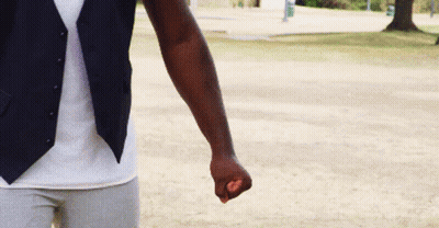 A Man Wearing A Vest And A White Shirt Is Holding A Purple Object In His Fist . GIF