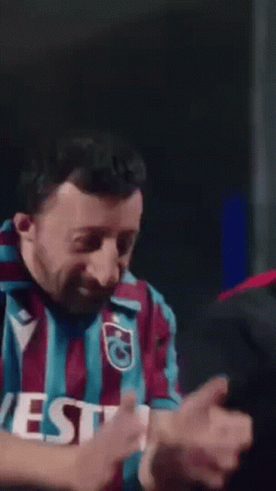 A Man Wearing A Vest Shirt Is Making A Funny Face . GIF
