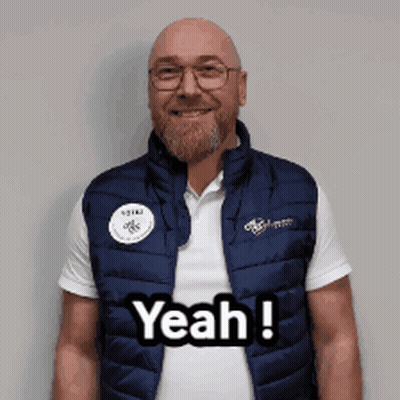 A Man Wearing A Vest That Says Yeah Is Smiling GIF