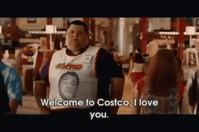 A Man Wearing A Vest With A Picture Of A Man On It Is Standing In Front Of A Crowd In A Store . GIF