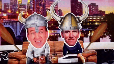 A Man Wearing A Viking Hat Sits Next To Another Man GIF