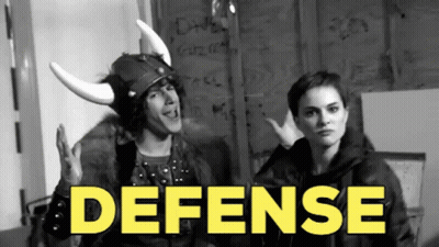 A Man Wearing A Viking Helmet Stands Next To A Woman With The Word Defense In Yellow GIF