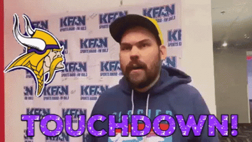 A Man Wearing A Vikings Helmet Is Standing In Front Of A Wall That Says Touchdown GIF