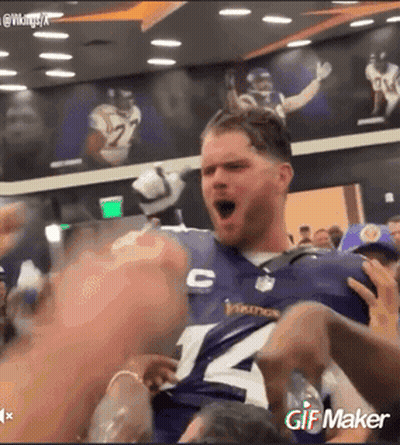 A Man Wearing A Vikings Jersey Is Being Held Up By Fans GIF