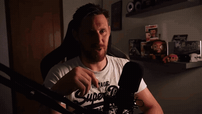 A Man Wearing A Vintage Super Dry T-Shirt Stands In Front Of A Microphone GIF