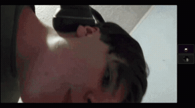 A Man Wearing A Virtual Reality Headset Is Laying On His Back GIF