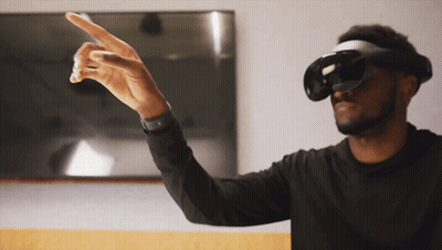 A Man Wearing A Virtual Reality Headset Is Pointing To Something GIF